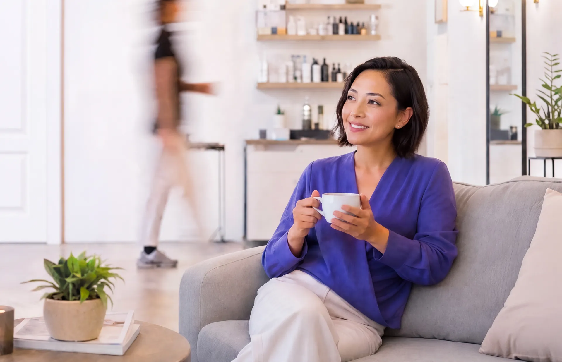Una dueña de negocio sonríe mientras disfruta de un café